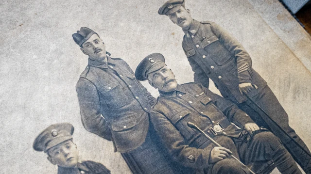 Foto antiga de um grupo de quatro homens com uniformes militares