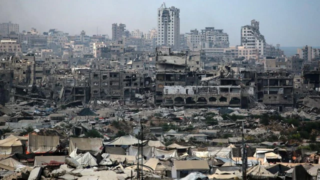 په غزې ښار کې د جګړې له امله زیانمنو شویو ودانیو ته نژدې، د بې ځایه شویو فلسطینیانو لخوا د لنډمهاله سرپناه په توګه د کېږدیو د کارولو عکس.