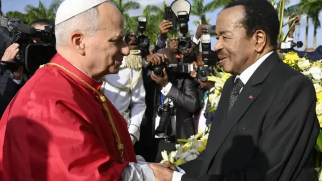 Pope Leo and Paul Biya hold hands