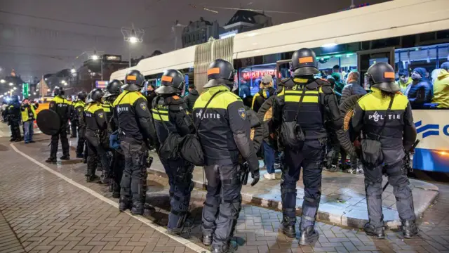 Около десяти полицейский перед трамваем в Амстердаме.