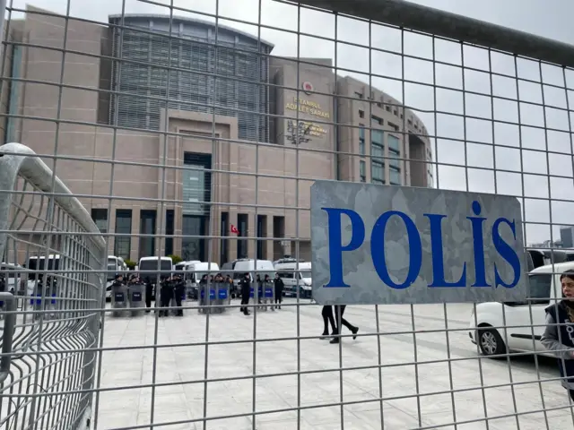 Çağlayan önündeki Çevik Kuvvet güçlerini gösteren fotoğraf. Önde üzerinde "Polis" yazan bir bariyer, arkada adliye binası gözüküyor.