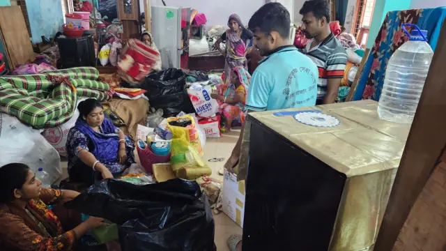 মালামাল নিয়ে একটি ভবনের নিচতলায় আশ্রয় নিয়েছেন অনেকে