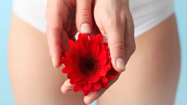 Woman in panties holding gerbera