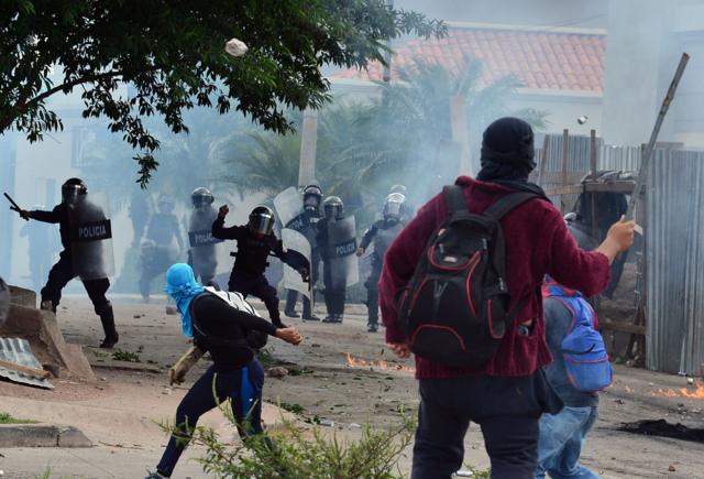 Manifestantes y policías se enfrentan en Honduras para pedir la renuncia de Hernández en 2021, ante indicios de sus vínculos con el narco