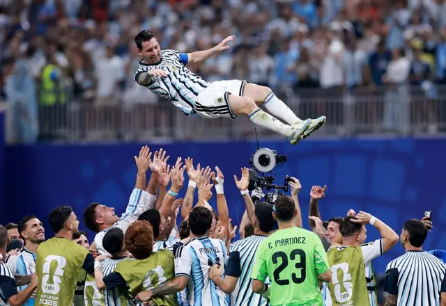 Messi sendo jogado pra cima pelos jogadores da Argentina