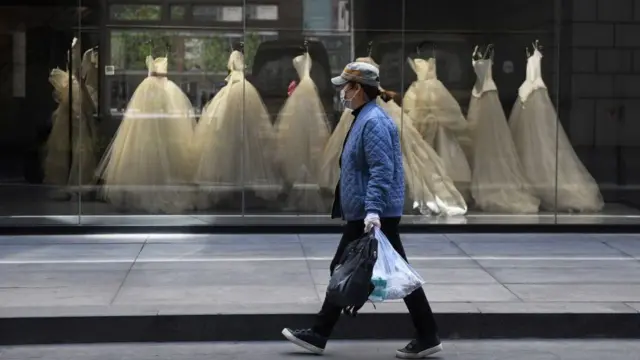 Một phụ nữ đi ngang qua tiệm bán đồ cô dâu