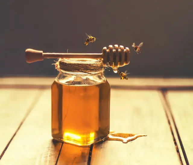 Miel avec des abeilles autour 