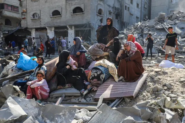 فلسطينيون يجلسون بالقرب من موقع الغارات الجوية الإسرائيلية على المنازل في مخيم الشاطئ للاجئين في مدينة غزة، 12 سبتمبر/أيلول 2025.