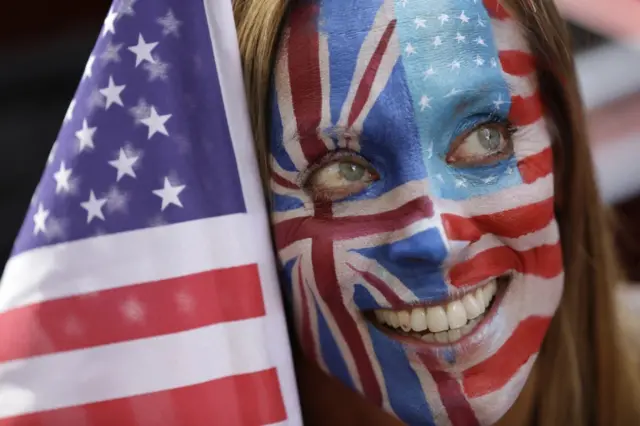 Mujer con la cara pintada con la bandera de Estados Unidos y la de Reino Unido.