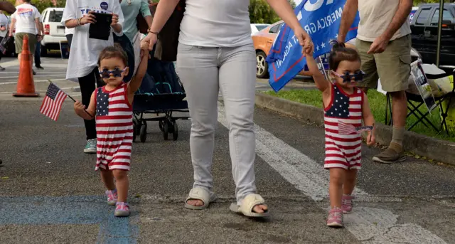 Niñas gemelas vestidas con la bandera de Estados Unidos