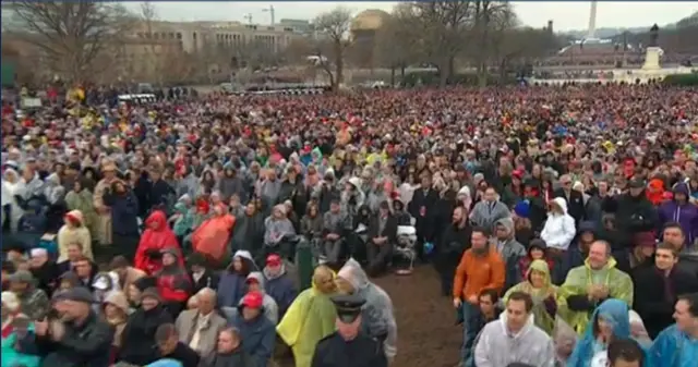 冒雨听总统致词的群众