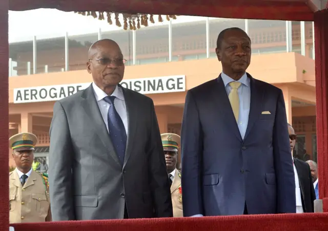 Le président sud-africain Jacob Zuma (à gauche) et son homologue guinéen Alpha Condé à l'aéroport international de Conakry le 13 janvier 2015 lors d'une visite officielle pour exprimer leur solidarité avec les trois pays les plus touchés par le virus Ebola et renforcer la coopération entre la Guinée et l'Afrique du Sud