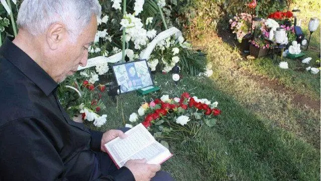 تصویری از پدر مریم میرزاخانی در حال خواندن قرآن بر مزار او