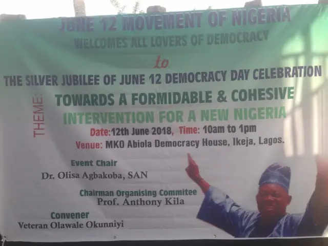 Àwòrán asọ ẹgbẹ́ June 12 Movement of Nigeria tó ń kí àwọn ènìyàn káàbọ̀ sílé olóògbé