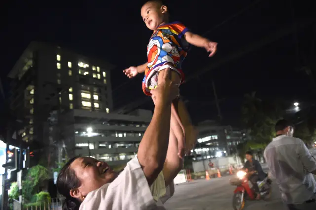 Một phụ nữ tung con trai lên vì vui mừng khi xe cứu thương chở các em trai được giải cứu đến bệnh viện ở Chiang Rai hôm 10/7