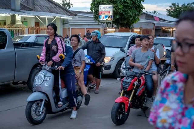 Người dân chờ đợi và reo mừng khi xe cứu thương chở cậu bé thứ 10 từ bãi đỗ trực thăng tới bệnh viện  Chiangrai Prachanukroh hôm 10/7