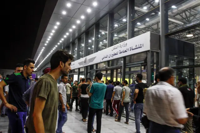 متظاهرون أمام المدخل الرئيس لمطار النجف الدولي مساء أمس. تقول السلطات العراقية أن حركة الطيران عادت إلى طبيعتها اليوم.