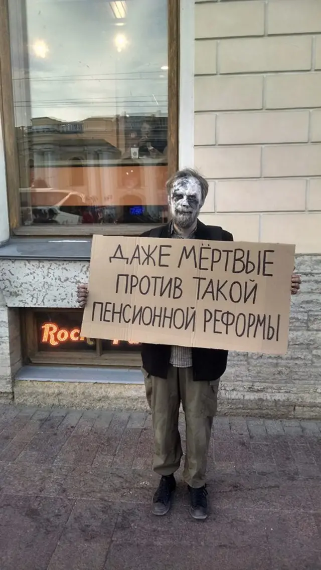 Протестующий в гриме мертвеца с табличкой