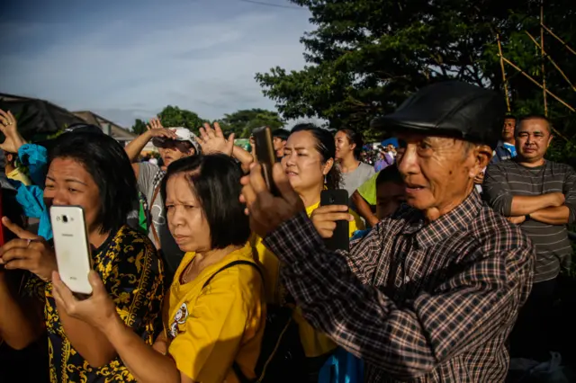 ประชาชนที่รวมตัวกันมาให้กำลังใจต่างพากันถ่ายรูปและโห่ร้องด้วยความดีใจขณะเฮลิคอปเตอร์บินผ่าน