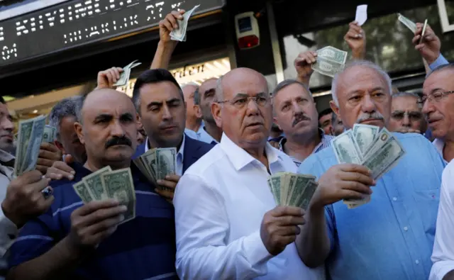 رجال أعمال أتراك في أنقرة أمام مكتب صرافة يحملون دولارات بعد دعوة الرئيس التركي شعبه لبيع الدولار من أجل دعم العملة التركية