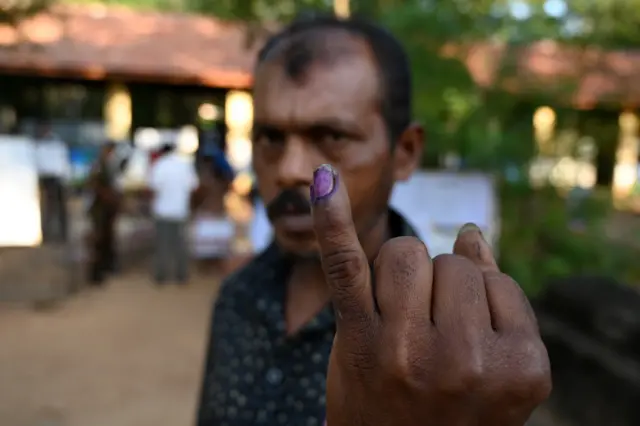 A man shows his inked finger outside a polling station after casting his vote during the country's presidential election in Weerawila on November 16, 2019. - Sri Lankans voted on November 16 for a new president in what could mark a comeback for the Rajapaksa clan, lauded by supporters for crushing the Tamil Tigers but condemned by critics for war crimes, corruption and cosying up to China.