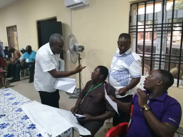 Returning Officer, Dr. W. A Olusende (left) try to explain why im for like announce Akwa Ibom North West senatorial district result for INEC headquarter as im dey fear for im safety.