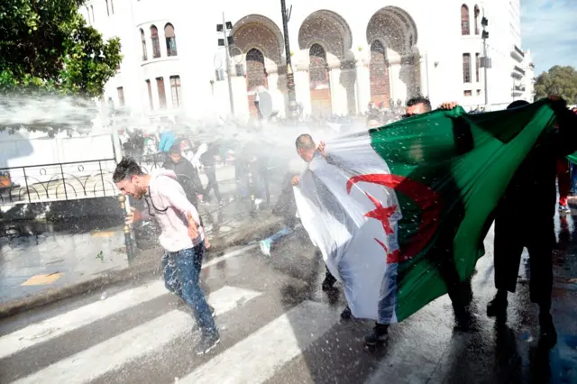 قوات مكافحة الشغب في الجزائر تستخدم المياه ضد متظاهرين يطالبون برحيل الرئيس المؤقت عبد القادر بن صالح