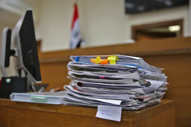 مستندات داخل القاعة التي تجري فيها المحاكمة