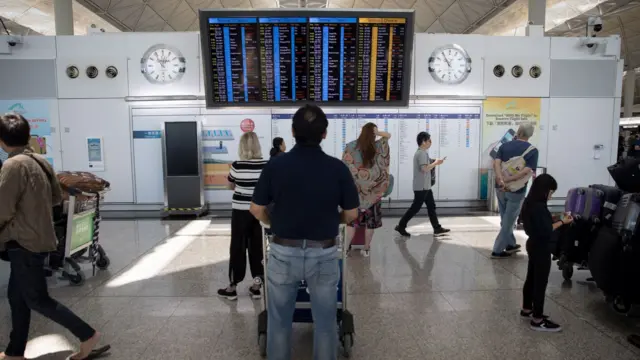 香港国际机场一号客运大楼内一名旅客驻足查看航班讯息（5/8/2019）
