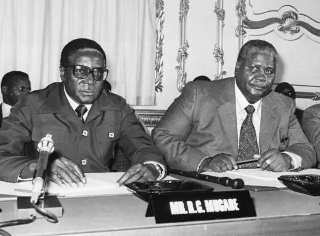 Robert Mugabe (Bidix) iyo Joshua Nkomo(Midig) oo sannadkii 1979-kii ku sugnaa dalka Ingiriiska