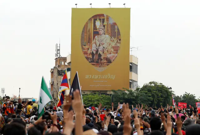 ผู้ชุมนุมชูสัญลักษณ์สามนิ้วขณะเคลื่อนขบวน
