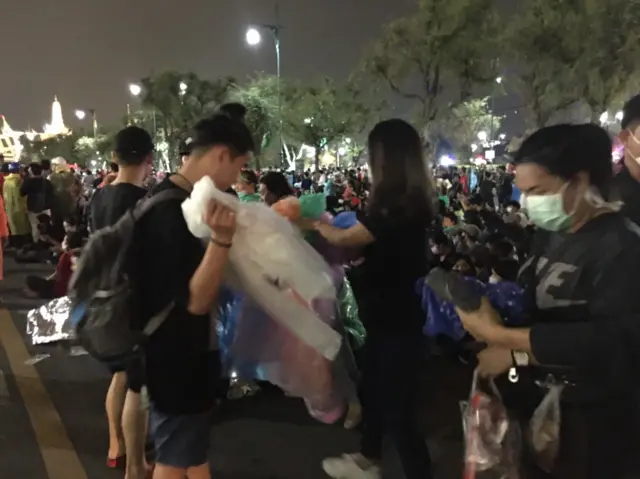 ผู้ชุมนุมแบ่งปันชุดกันฝน