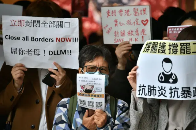 Protesters hold up banners and placards during a "flash mob" gathering to demand the government close its border with mainland China to reduce the spread of the deadly SARS-like virus to Hong Kong on February 3, 2020.