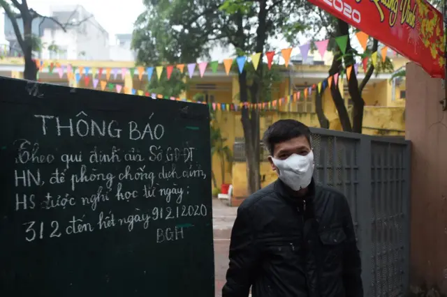 A security staff stands at the entrance of a primary school closed to prevent the spread of corona virus in Hanoi on February 3, 2020