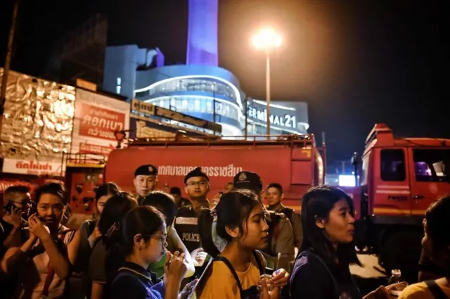 People gather together after being rescued by Thai commandos from Terminal 21