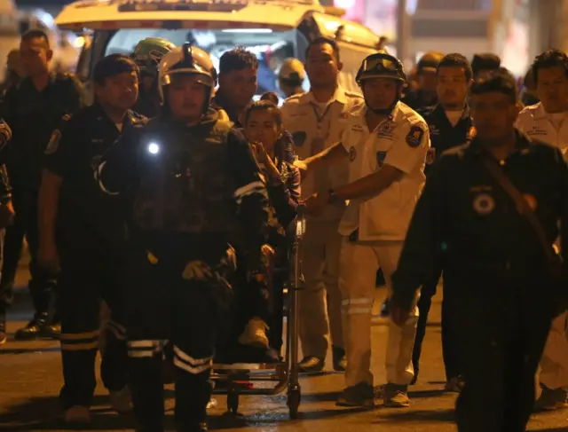 Thai woman (C) sits on the wheelchair after she was rescued by the officials from within the mall, after a suspected Thai soldier opened fire in a rampage at the Terminal 21
