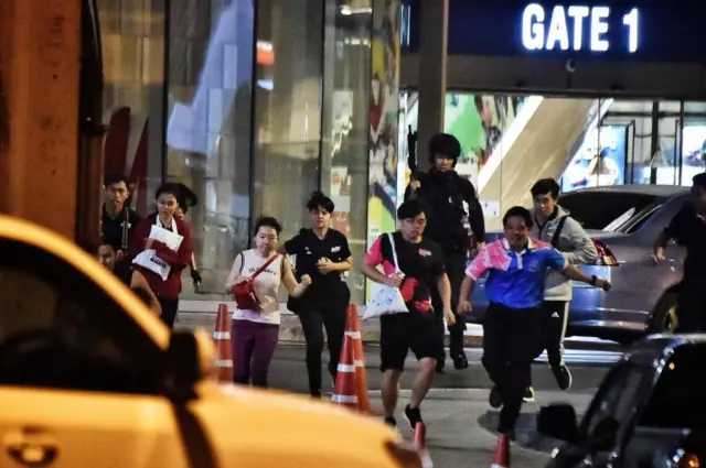 People run together as they are rescued by Thai commandos from Terminal 21 shopping mall