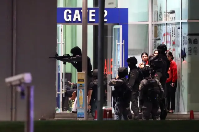 Thailand security forces enter in a shopping mall as they chase a shooter hidden in after a mass shooting in front of the Terminal 21