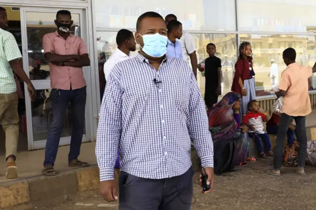 مواطن سوداني يرتدي الكمامة في محطة للحافلات في الخرطوم
