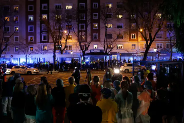 Sanitary personal stands by a hospital while Madrid's police corps applaud them