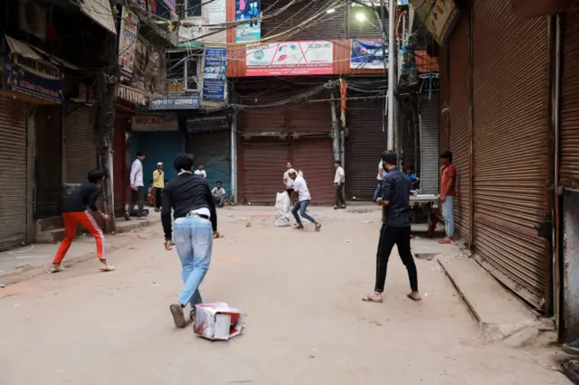 دلی میں بچے بند دکانوں کے باہر کرکٹ کھیل رہے ہیں