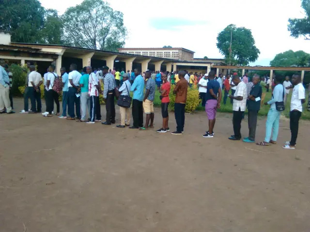 Kw'ishure ryisumbuye ESTA Rohero bari batonze imirongo imbere y'isaha cumi nazibiri