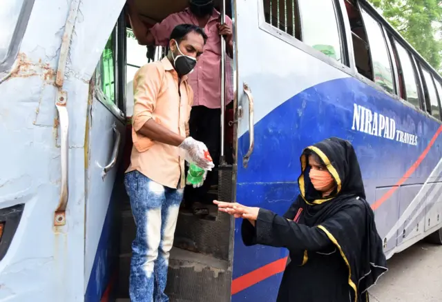 বাসে ওঠার আগে স্যানিটাইজার নিচ্ছেন এক যাত্রী