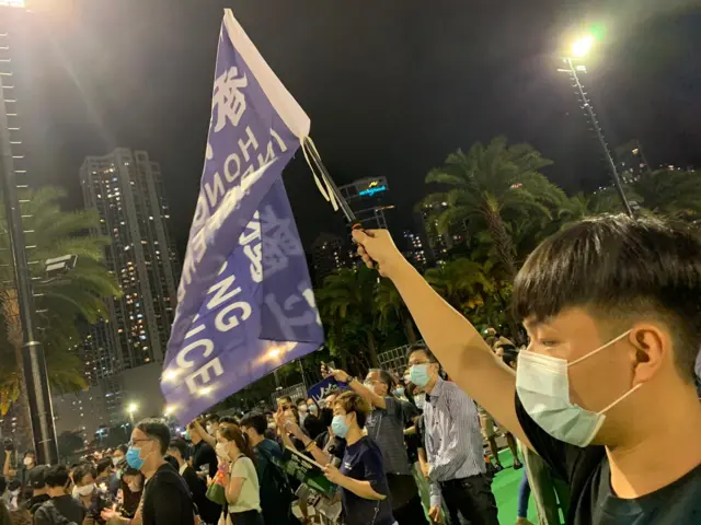 18岁的李同学今年首次参加六四晚会，他在人群中高举“香港独立”的旗帜。