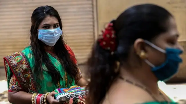 कोरोना वायरस के दौर में सार्वजनिक स्थल पर पूजा अर्चना में शामिल होती हुईं एक महिला