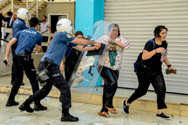 Gösterici bir kadına müdahale eden bir polis