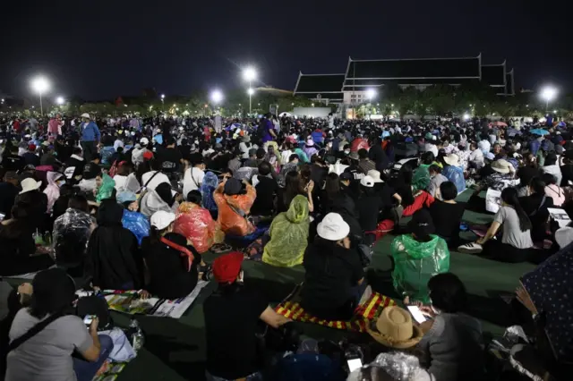 ประชาชนนั่งฟังผู้ปราศรัยบนเวทีที่สนามหลวง