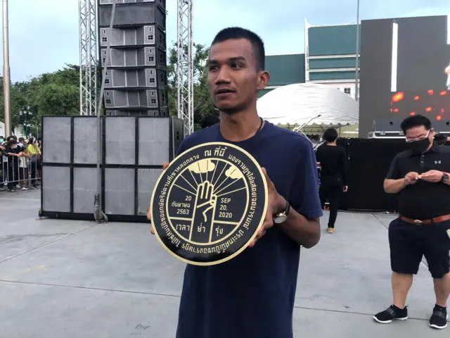 ภาณุพงศ์ จาดนอก แสดงแบบจำลอง "หมุดคณะราษฎร" ของผู้ชุมนุม