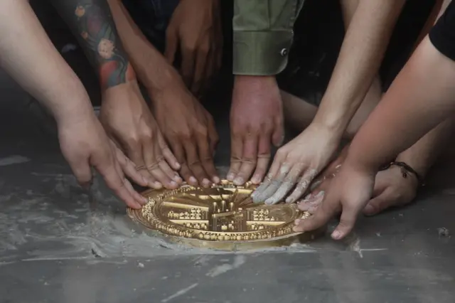 แกนนำผู้ชุมนุมนำมือแตะที่หมุดพร้อมกัน