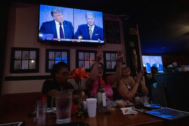 支持特朗普的妇女在观看电视辩论时为总统加油
